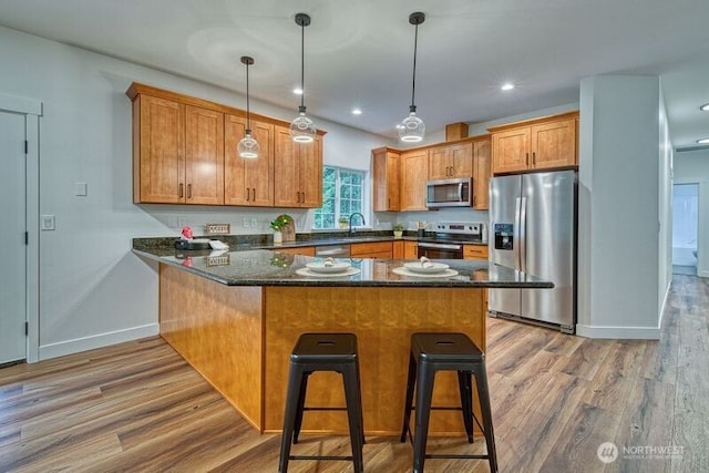 2822 200th Ave SW, Lakebay, WA 98349 - kitchen with stainless steel appliances, a peninsula, wood finished floors, baseboards, and pendant lighting