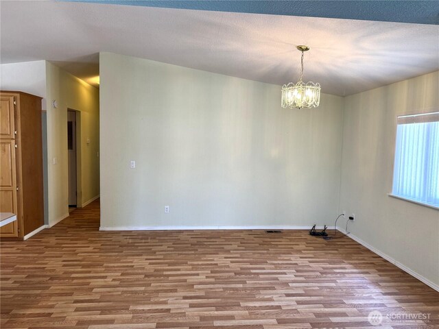 3010 W Peninsula Dr Unit 109, Moses Lake, WA 98837 - unfurnished room featuring wood finished floors, a chandelier, and baseboards