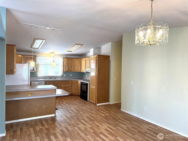 3010 W Peninsula Dr Unit 109, Moses Lake, WA 98837 - kitchen featuring stove, wood finished floors, a sink, track lighting, and a chandelier