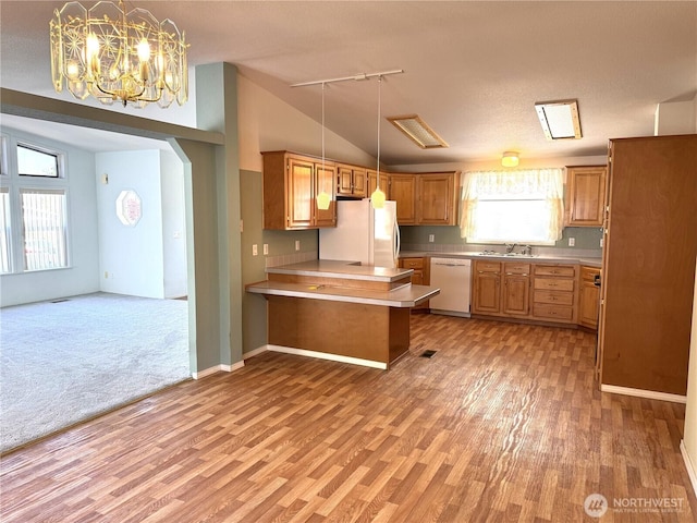 3010 W Peninsula Dr Unit 109, Moses Lake, WA 98837 - kitchen with white appliances, track lighting, a peninsula, vaulted ceiling, and light wood-type flooring