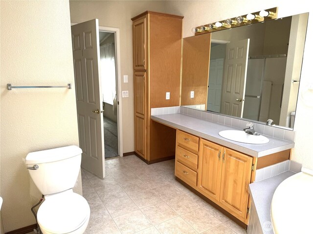 3010 W Peninsula Dr Unit 109, Moses Lake, WA 98837 - bathroom featuring vanity, toilet, a tub to relax in, and tile patterned floors