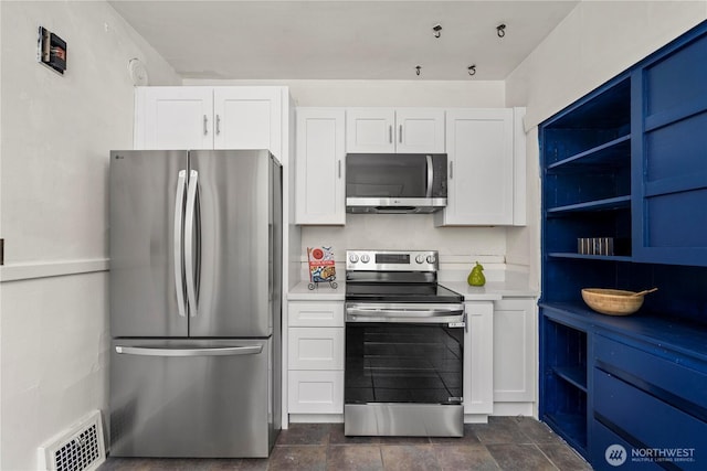 kitchen with visible vents, white cabinets, light countertops, and stainless steel appliances