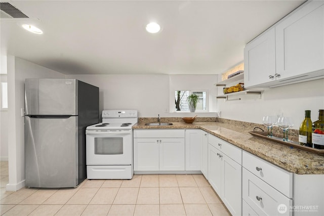 kitchen with freestanding refrigerator, light tile patterned floors, open shelves, a sink, and electric stove