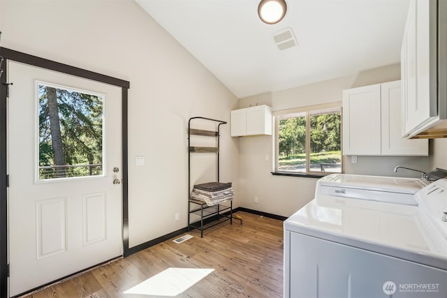 701 Emerick Rd, Cle Elum, WA 98922 - clothes washing area with cabinet space, washing machine and dryer, light wood finished floors, and baseboards