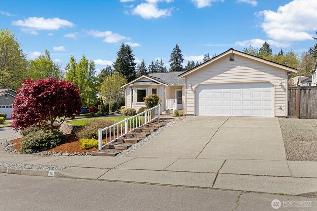 single story home featuring concrete driveway, an attached garage, and fence