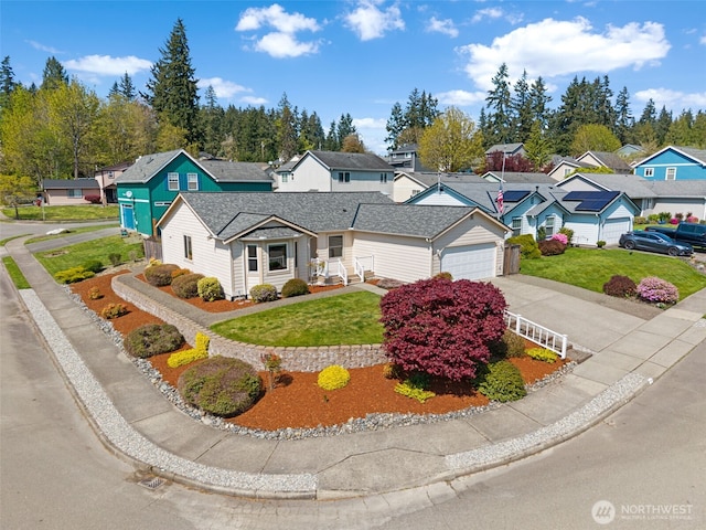 view of front of home featuring concrete driveway, a front yard, a residential view, and a garage