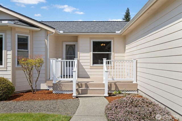 entrance to property featuring a shingled roof