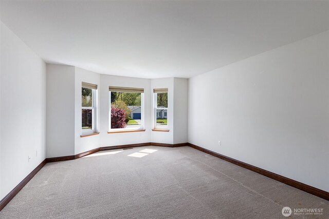 carpeted spare room featuring visible vents and baseboards