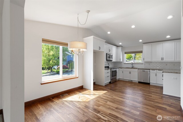 kitchen featuring tasteful backsplash, a sink, appliances with stainless steel finishes, visible vents, and an inviting chandelier