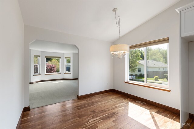unfurnished dining area with an inviting chandelier, a healthy amount of sunlight, and baseboards