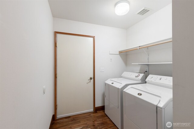 laundry room featuring separate washer and dryer, laundry area, visible vents, baseboards, and wood finished floors