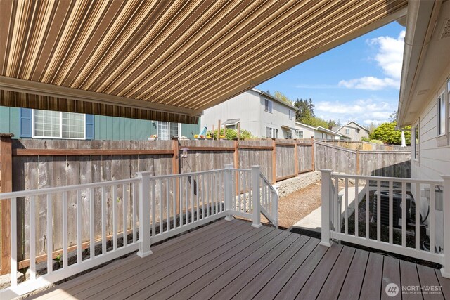 wooden terrace featuring a residential view and a fenced backyard