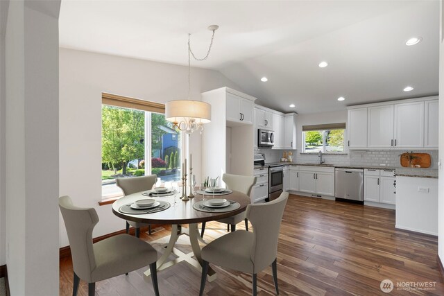 dining room with dark wood-style floors, recessed lighting, an inviting chandelier, and vaulted ceiling