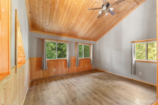 unfurnished room with a wainscoted wall, wood ceiling, wood finished floors, wood walls, and lofted ceiling