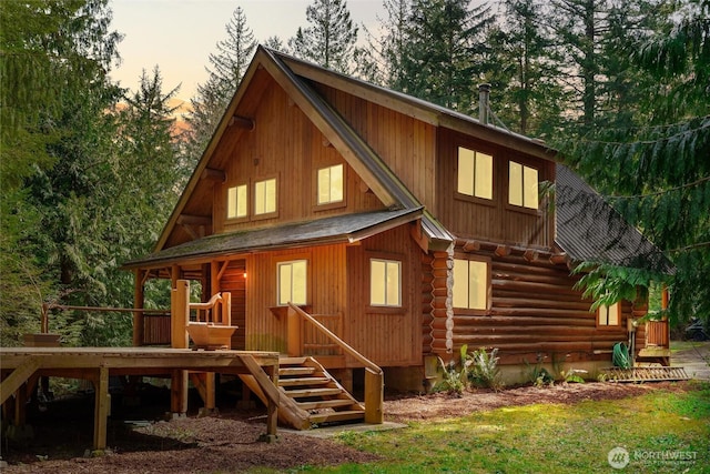 back of property at dusk featuring log exterior