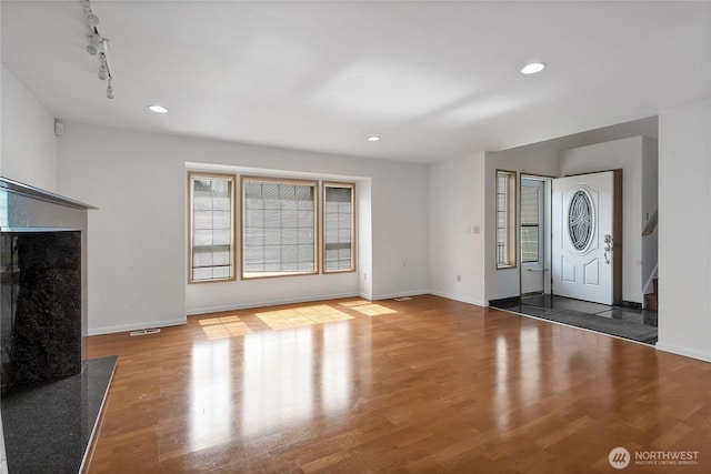 8703 232nd Street Ct E, Graham, WA 98338 - unfurnished living room with baseboards, plenty of natural light, and wood finished floors