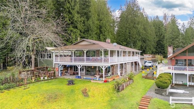 3058 Camp 2 Rd, Sedro Woolley, WA 98284 - rear view of house with an outdoor fire pit, a patio, a lawn, a wooden deck, and a chimney
