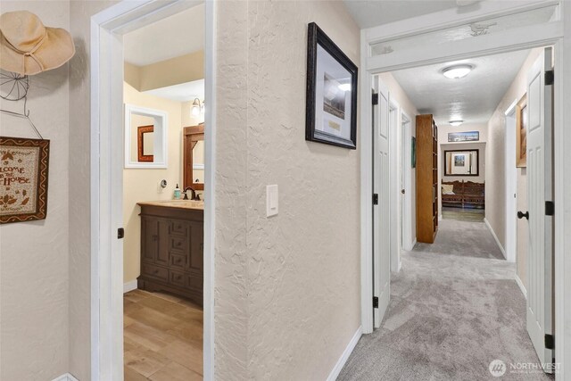 3058 Camp 2 Rd, Sedro Woolley, WA 98284 - corridor with a textured wall, a sink, and baseboards