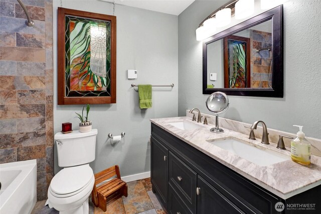 3058 Camp 2 Rd, Sedro Woolley, WA 98284 - full bathroom with double vanity, toilet, baseboards, stone finish floors, and washtub / shower combination