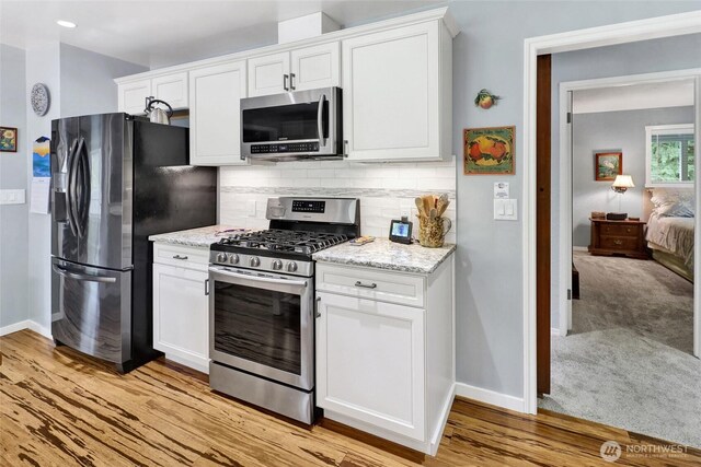 3058 Camp 2 Rd, Sedro Woolley, WA 98284 - kitchen featuring stainless steel appliances, baseboards, backsplash, white cabinets, and light stone counters