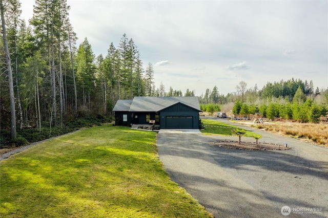 view of front facade with a front lawn, a garage, and aphalt driveway