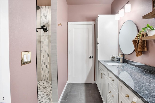 bathroom with a walk in shower, tile patterned floors, and vanity