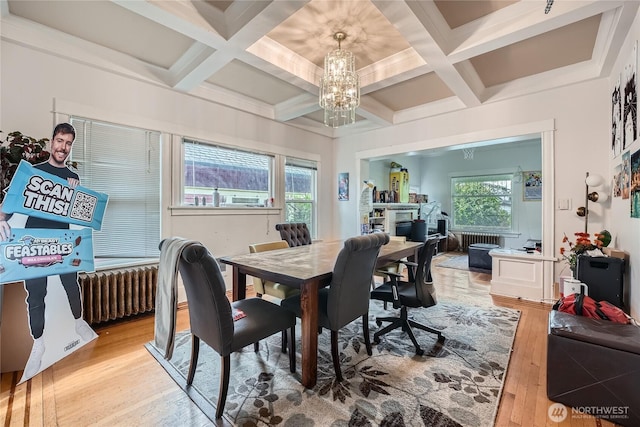 dining area with coffered ceiling, light wood-type flooring, plenty of natural light, and a notable chandelier