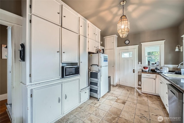 kitchen with appliances with stainless steel finishes, a sink, white cabinets, and dark countertops