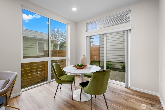 dining space with wood finished floors, baseboards, and recessed lighting