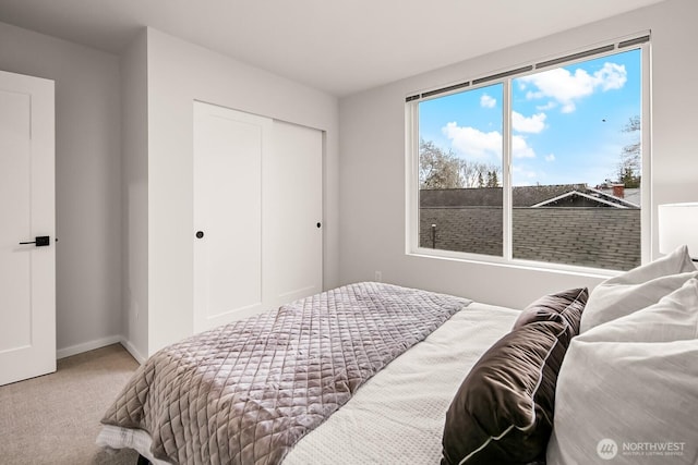 carpeted bedroom featuring a closet and baseboards