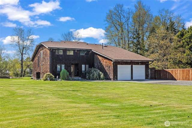 view of front facade featuring an attached garage, driveway, a front lawn, and fence