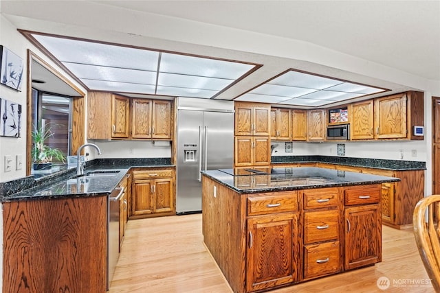kitchen with brown cabinetry, a sink, and appliances with stainless steel finishes