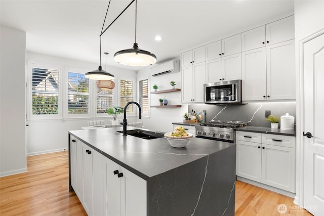 kitchen with stainless steel microwave, dark countertops, a wall unit AC, stove, and a sink