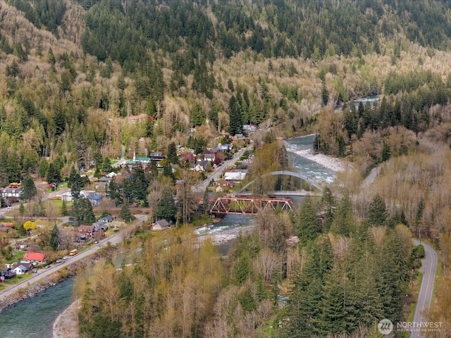 drone / aerial view with a forest view and a water view