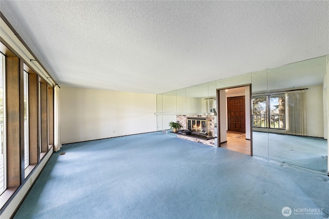 478 SW Judson Dr, Oak Harbor, WA 98277 - unfurnished living room featuring a fireplace, carpet, and a textured ceiling