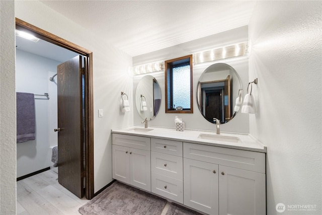 478 SW Judson Dr, Oak Harbor, WA 98277 - bathroom with wood finished floors, double vanity, a sink, and baseboards