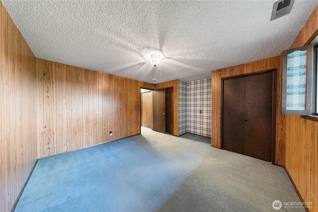 478 SW Judson Dr, Oak Harbor, WA 98277 - unfurnished bedroom featuring wooden walls, carpet, and a textured ceiling