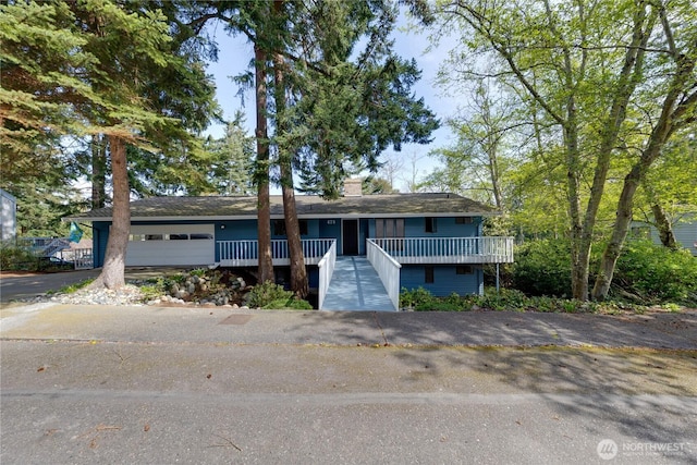 478 SW Judson Dr, Oak Harbor, WA 98277 - view of front of house with an attached garage, a chimney, aphalt driveway, and a porch