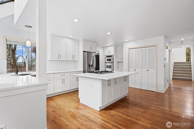 13923 SE 79th Dr, Newcastle, WA 98059 - kitchen with light countertops, white cabinetry, light wood-style floors, appliances with stainless steel finishes, and a sink