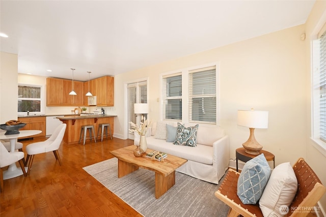 living area featuring recessed lighting, baseboards, and wood finished floors