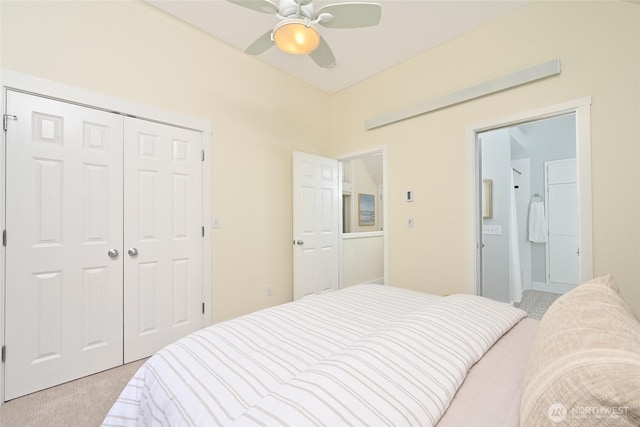 bedroom featuring ceiling fan, light carpet, a closet, and connected bathroom