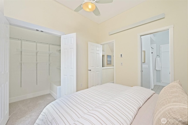 carpeted bedroom featuring connected bathroom, ceiling fan, baseboards, and a closet