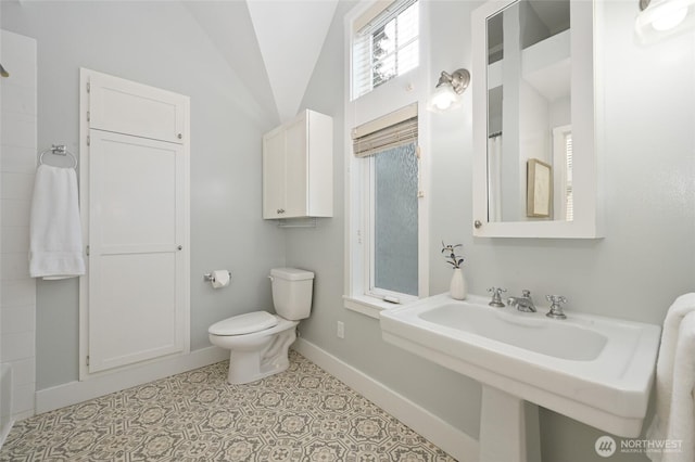 bathroom with baseboards, curtained shower, vaulted ceiling, and toilet