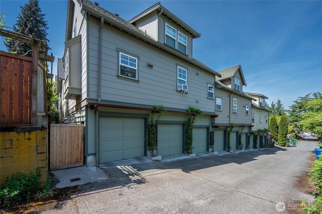 exterior space with fence, cooling unit, and a garage
