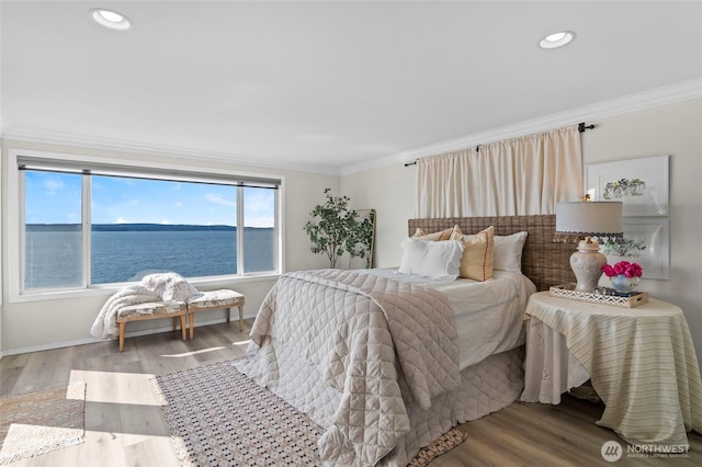 bedroom featuring baseboards, wood finished floors, recessed lighting, and ornamental molding