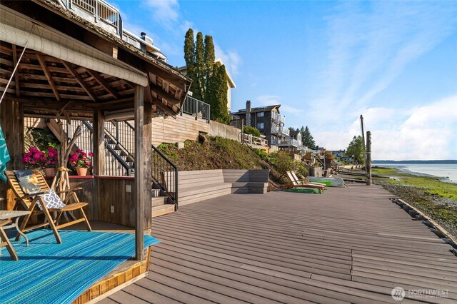 wooden deck with stairs and a water view
