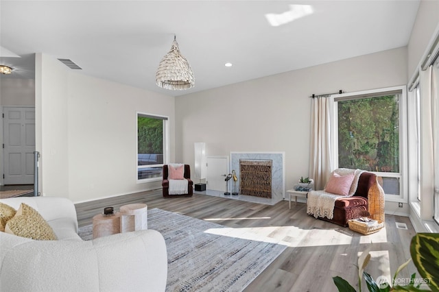 living room featuring visible vents, wood finished floors, and a wealth of natural light