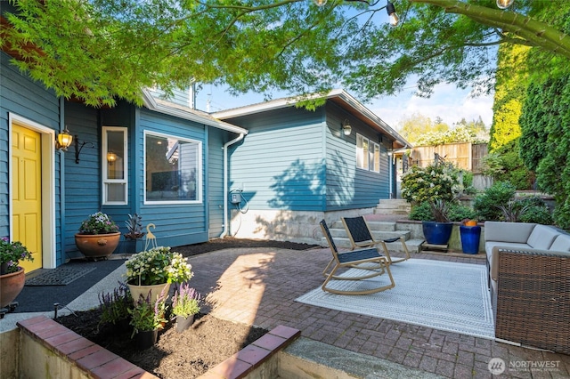 rear view of property featuring fence, outdoor lounge area, and a patio