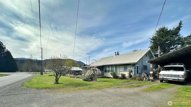 107 Martin Rd, Glenoma, WA 98336 - view of front of house with a carport, metal roof, driveway, and a front lawn