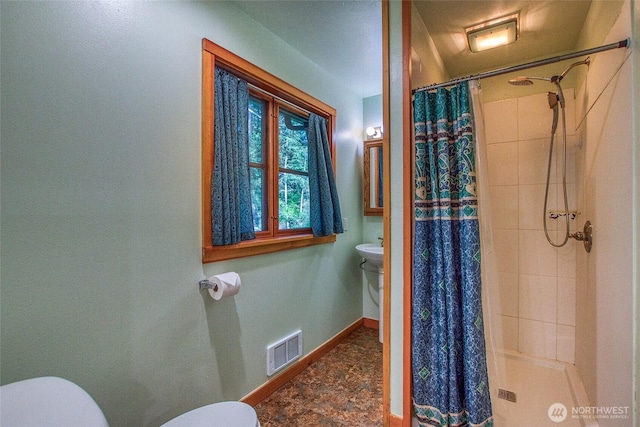bathroom with toilet, baseboards, visible vents, and a stall shower